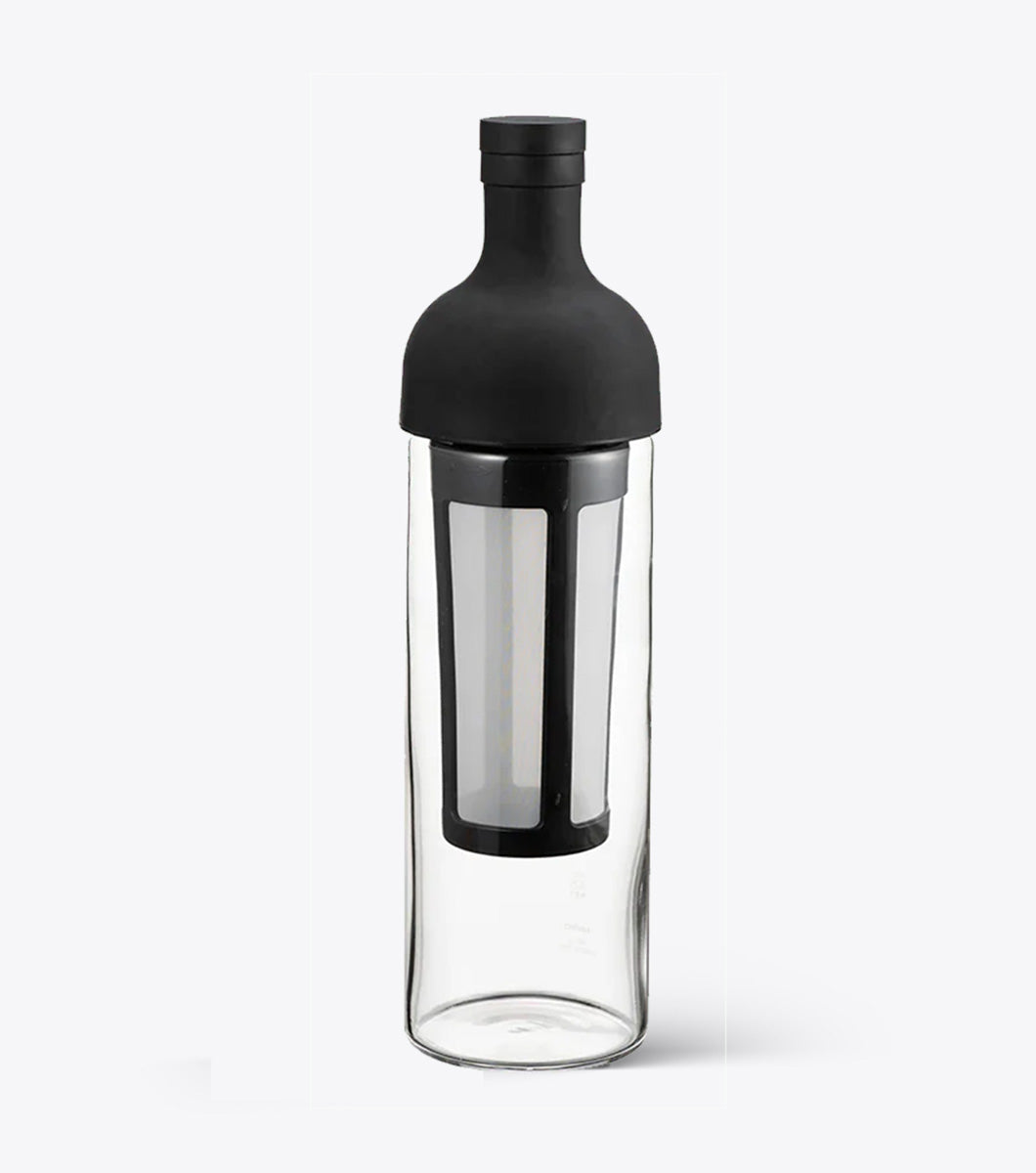 Hario clear glass bottle with black cap and interior filter on a white background