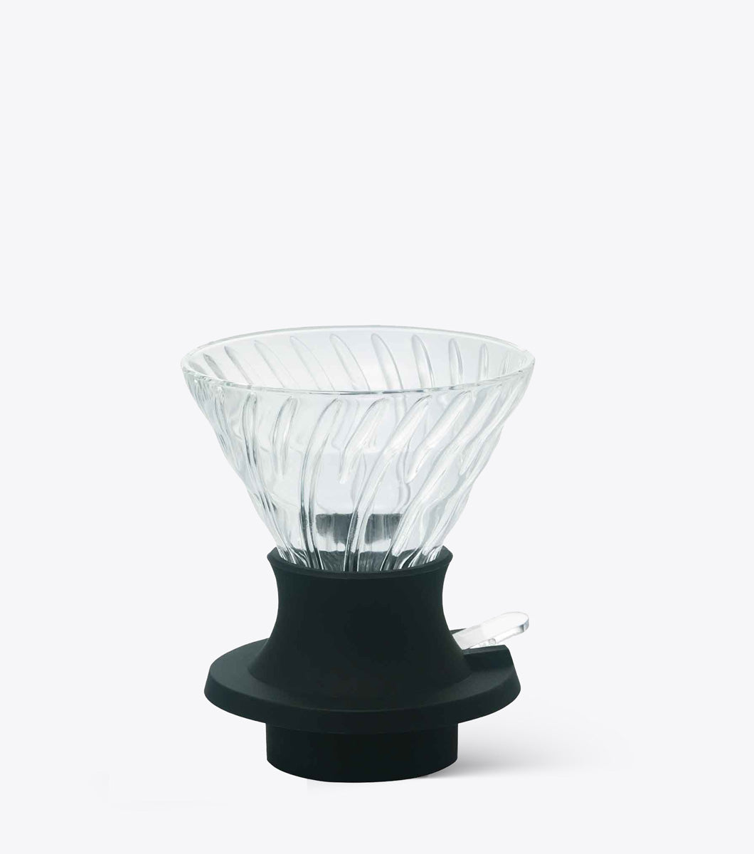 Clear glass coffee dripper with black base on a white background